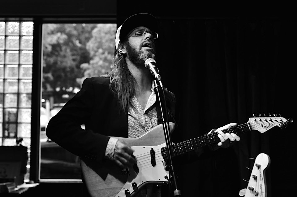 Black and white photograph of musician Chris Peck at Peri's Tavern