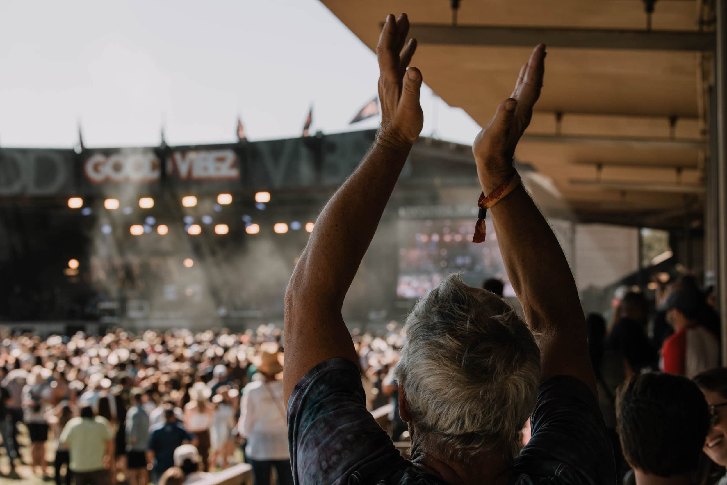 A fan claps for Jamestown Revival performing on the Steelhead Stage. 