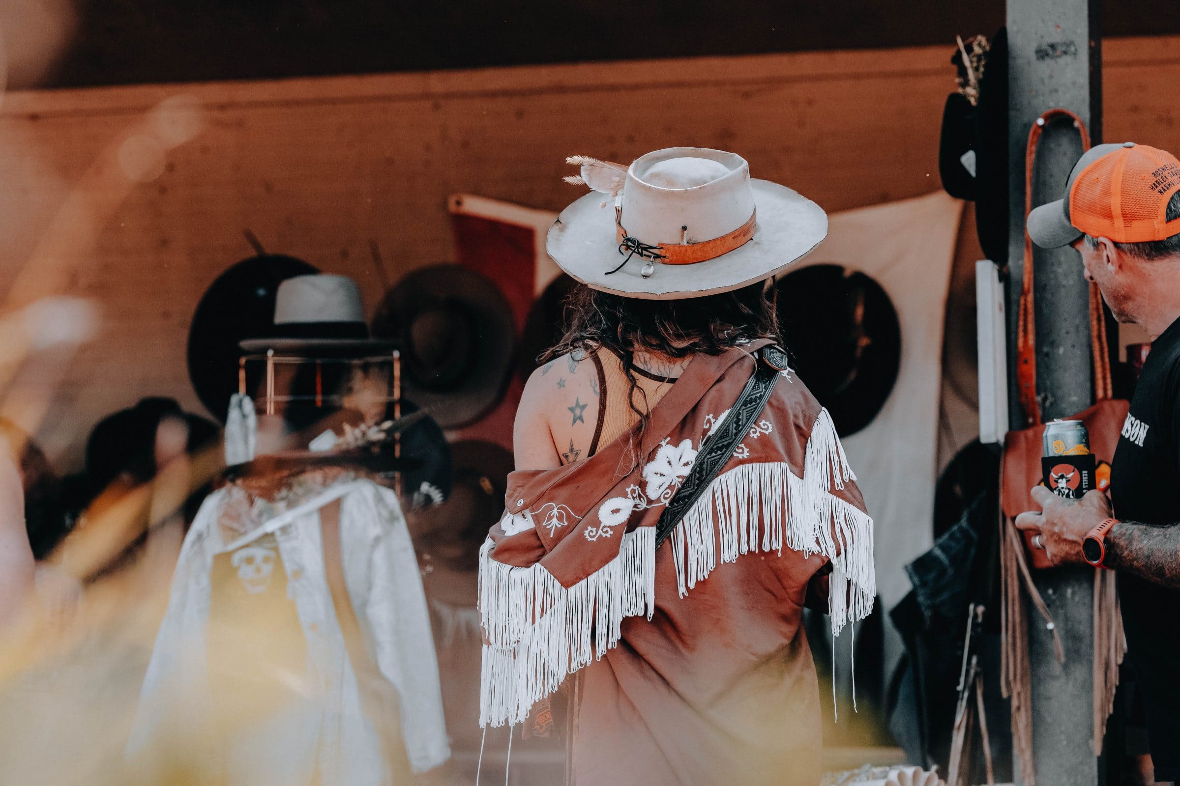 A festival goer checks out hand-crafted hats for sale at one of the many local vendors' tents.